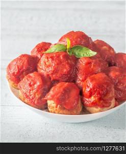 Bowl of meatballs with tomato sauce and fresh basil