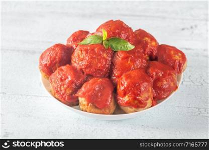 Bowl of meatballs with tomato sauce and fresh basil