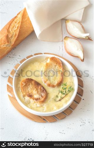 Bowl of onion soup with fresh thyme on the table
