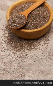 Bowl of organic natural chia seeds close-up on concrete background or table. High quality photo. Bowl of organic natural chia seeds close-up on concrete background or table
