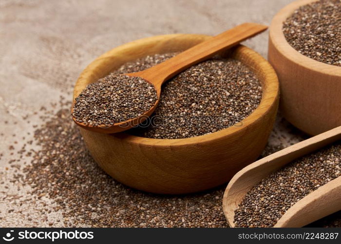 Bowl of organic natural chia seeds close-up on concrete background or table. High quality photo. Bowl of organic natural chia seeds close-up on concrete background or table