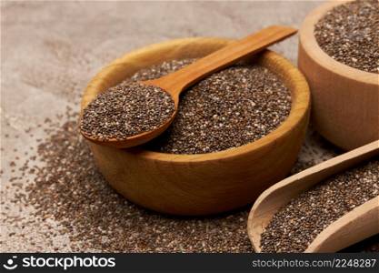 Bowl of organic natural chia seeds close-up on concrete background or table. High quality photo. Bowl of organic natural chia seeds close-up on concrete background or table