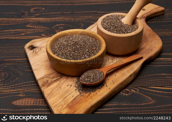 Bowl of organic natural chia seeds close-up on wooden background or table. High quality photo. Bowl of organic natural chia seeds close-up on wooden background or table