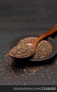 Bowl of organic natural chia seeds close-up on wooden background or table. High quality photo. Bowl of organic natural chia seeds close-up on wooden background or table