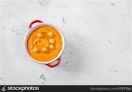 Bowl of paprika hummus on white background