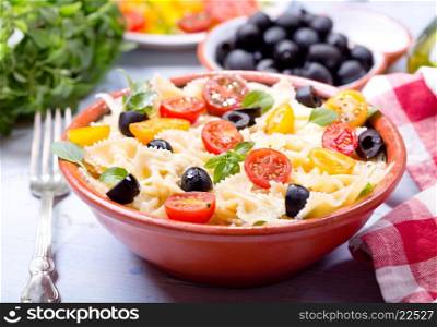bowl of pasta salad with vegetables on wooden table