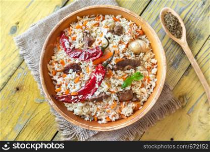 Bowl of pilaf on the wooden table: top view
