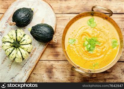 Bowl of pumpkin soup on rustic wooden table. Pumpkin soup on wooden table