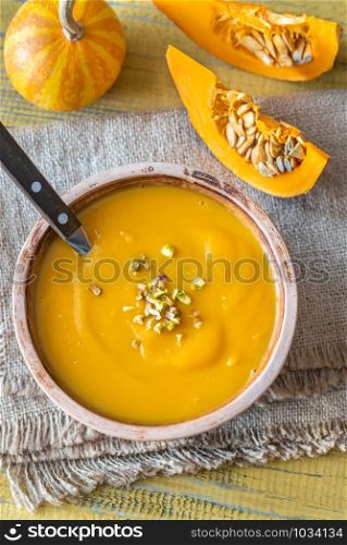 Bowl of pumpkin soup with wedges of fresh pumpkin