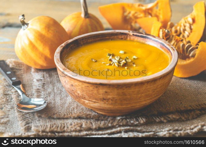 Bowl of pumpkin soup with wedges of fresh pumpkin