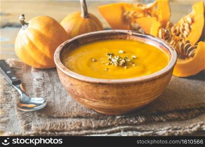 Bowl of pumpkin soup with wedges of fresh pumpkin