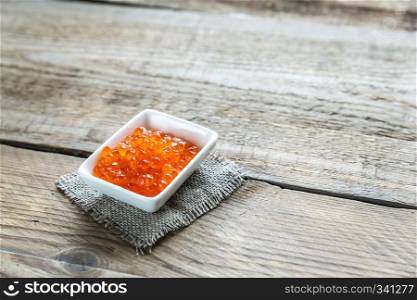 Bowl of red caviar on the wooden table