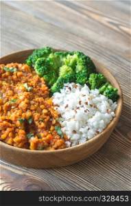 Bowl of red lentil curry with white rice and broccoli