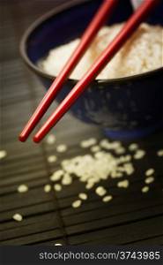Bowl of rice and chopsticks over black