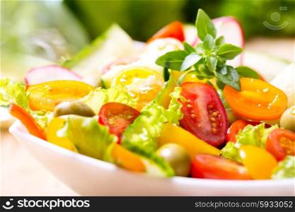bowl of salad with fresh vegetables on wooden table