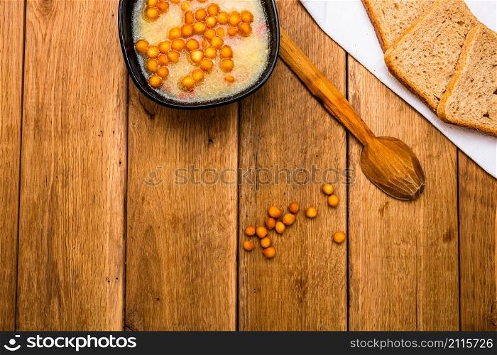 Bowl of soup with bread on wooden table