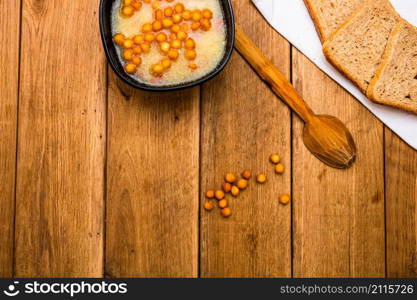 Bowl of soup with bread on wooden table