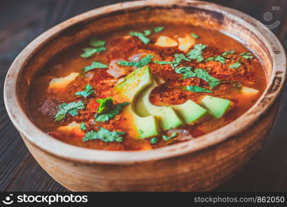 Bowl of spicy Mexican soup on the rustic background
