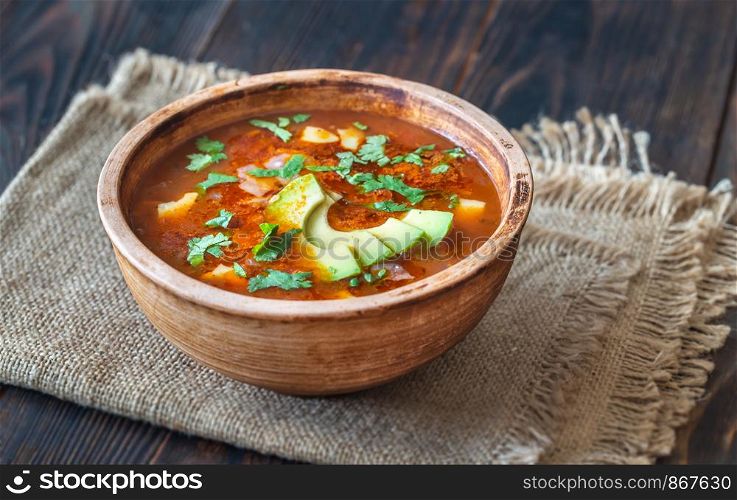 Bowl of spicy Mexican soup on the rustic background