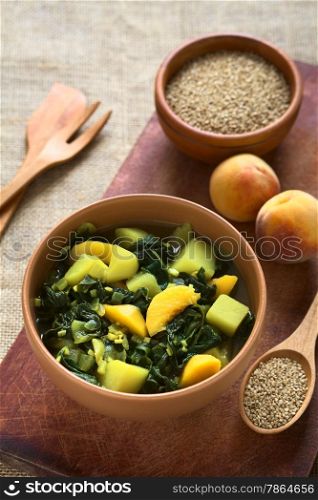 Bowl of spinach, peach and potato curry dish with sesame seeds and peaches in the back photographed with natural light (Selective Focus, Focus in the middle of the curry dish)