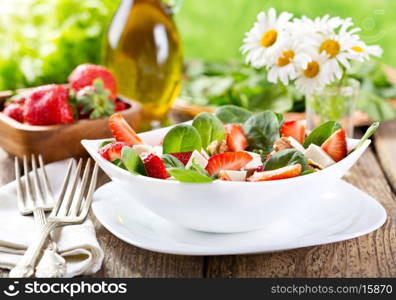 bowl of strawberry salad on wooden table