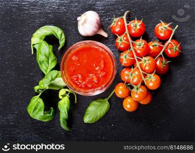 bowl of tomato sauce with fresh basil, garlic and tomatoes, top view