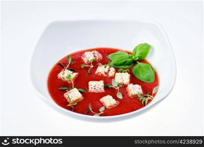 Bowl of tomato soup over white background