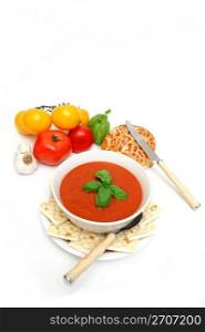 Bowl of tomato soup with crackers and a roll with fresh tomatoes isolated on a white background. Tomato Soup