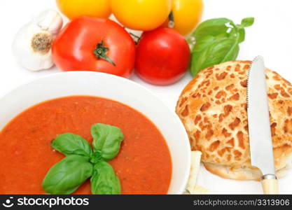 Bowl of tomato soup with crackers and a roll with fresh tomatoes isolated on a white background. Tomatoes And Tomato Soup