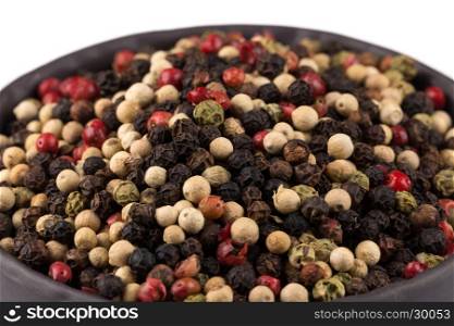 bowl of various pepper peppercorns seeds mix on white