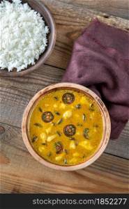 Bowl of yellow mushroom curry on the wooden table