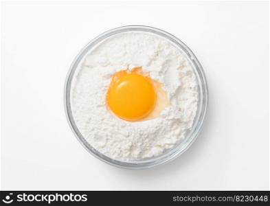 Bowl plate with flour and egg yolk on white background..Top view.