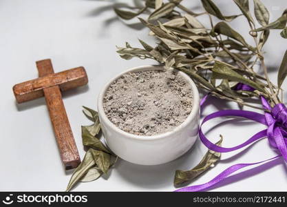 Bowl with ashes, olive branch and cross, symbols of Ash Wednesday. bowl with ashes and olive branch. ash wednesday concept