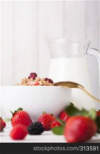 Bowl with cereal and fresh berries and jar of milk.Healthy summer breakfast