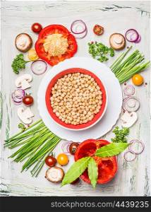 Bowl with Chickpeas and fresh delicious vegetables ingredients on light wooden background, top view. Vegan or vegetarian food concept