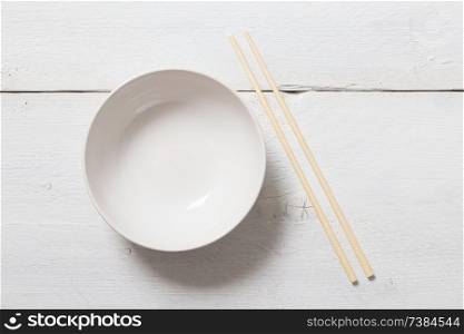 Bowl with chopsticks on wooden bird&rsquo;s eye view.. Bowl with chopsticks on wooden bird&rsquo;s eye view