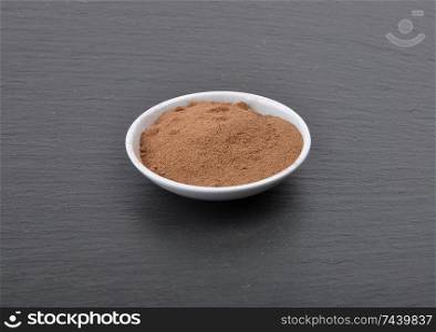 Bowl with cocoa powder on shale