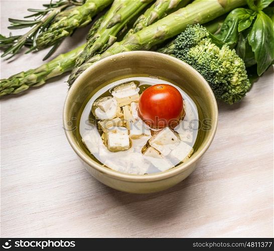 Bowl with Diced feta cheese and green vegetables, close up