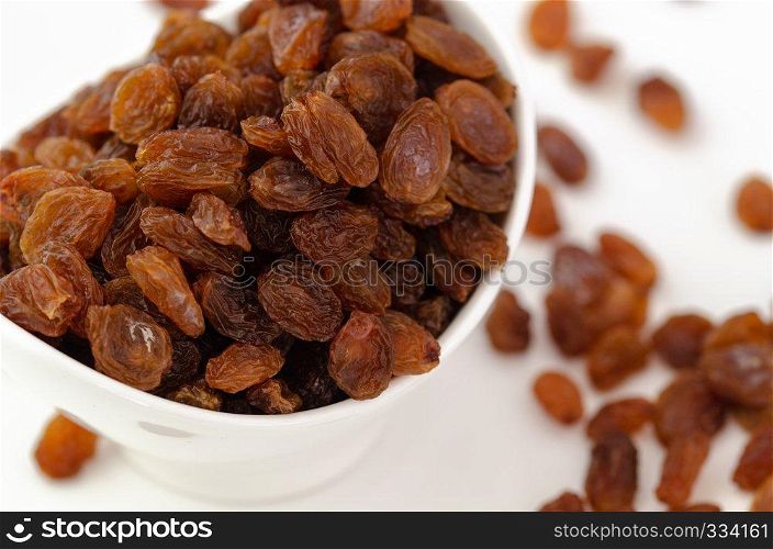 Bowl with dried raisins on white background , top view. Healthy nutrition with fruits
