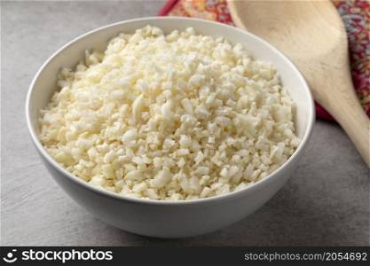 Bowl with fresh raw cauliflower rice close up