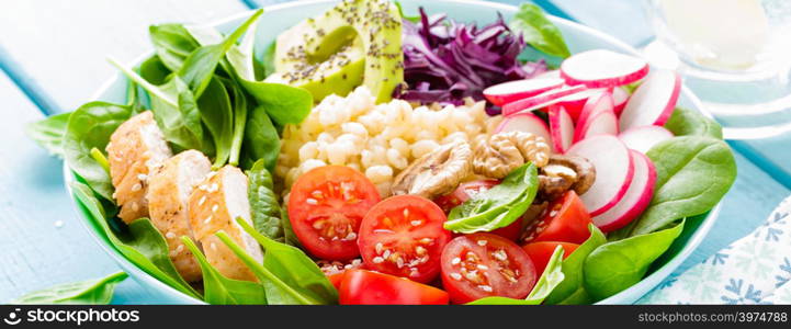 Bowl with grilled chicken meat, bulgur and fresh vegetable salad of radish, tomatoes, avocado, kale and spinach leaves. Healthy and delicious summer lunch. Banner