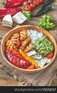 Bowl with grilled chicken, rice, blue cheese and vegetables