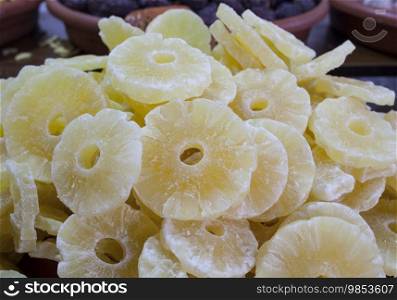 Bowl with pineapple dried fruit. Slices displayed at street market stall