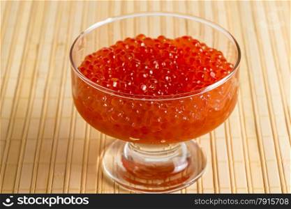 bowl with red caviar on a bamboo napkin