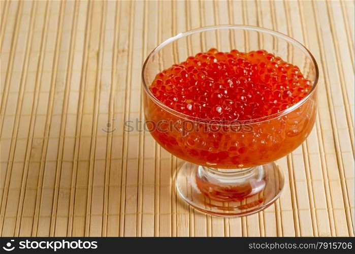 bowl with red caviar on a bamboo napkin closeup