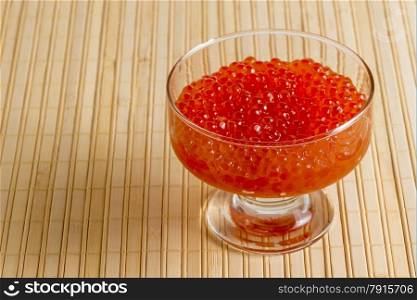 bowl with red caviar on a bamboo napkin closeup