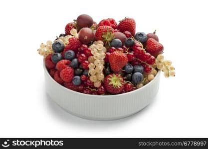 Bowl with summer fruit on white background