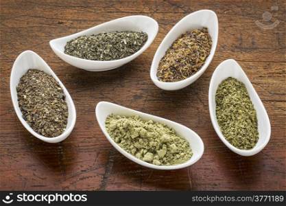 bowls of seaweed diet supplements (bladderwrack, sea lettuce, kelp, wakame and Irish moss) on a rustic wood table