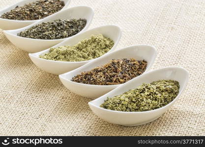 bowls of seaweed diet supplements (bladderwrack, sea lettuce, kelp, wakame and Irish moss) on burlap canvas