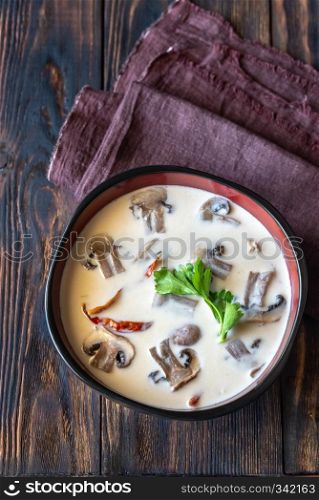 Bowls of thai tom kha soup on the wooden table